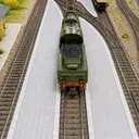 Modellbahnanlage in Spur H0: helle Bahnsteige aus dem 3D-Druck an mehreren Gleisen, dazwischen eine Dampflokomotive